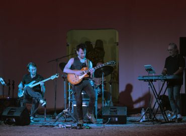 Man met gitaar op podium